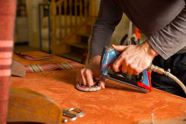 man upholstering a sofa