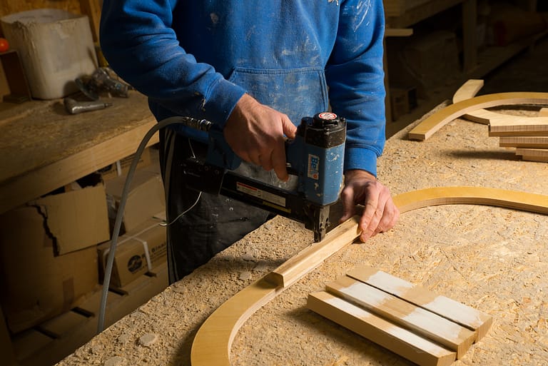 man making furniture with nail gun